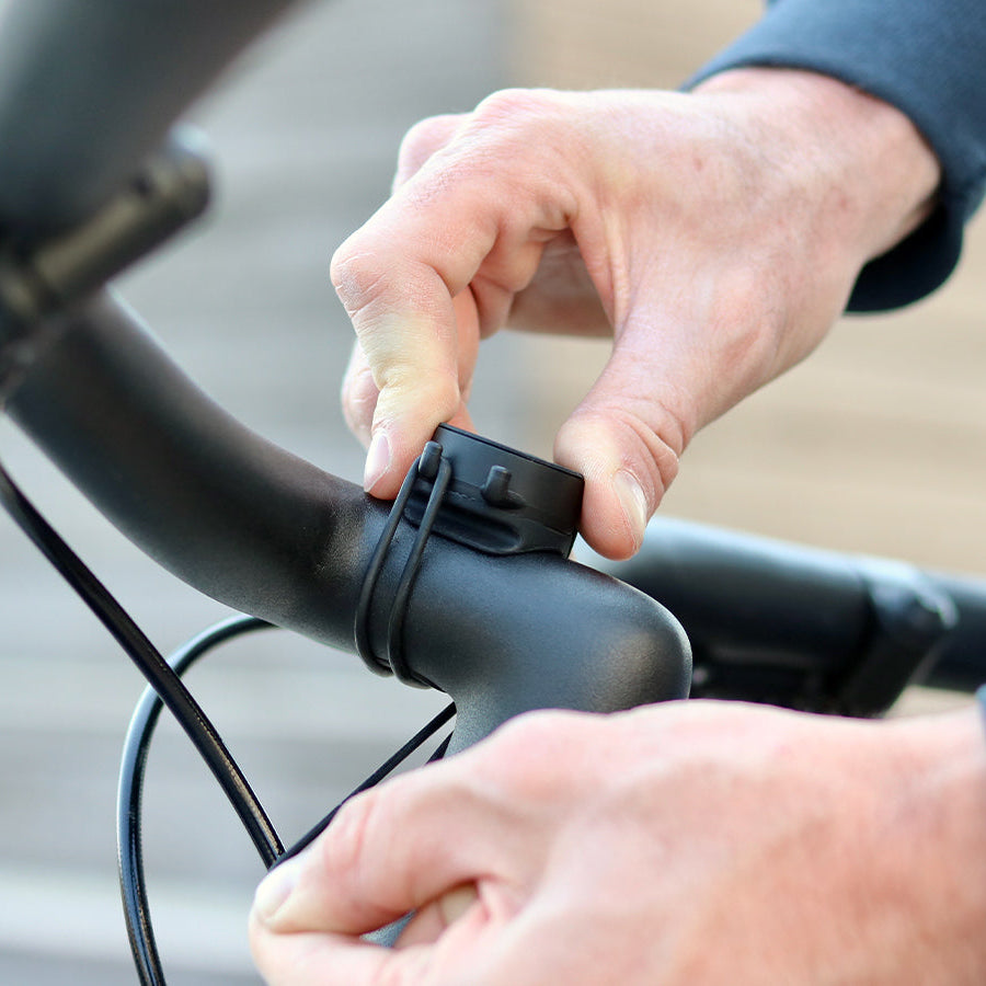 Montage des Halters an einem Fahrradlenker mit den 2 Gummibändern. Einfache und schnelle Montage – die Gummibänder sind robust und sorgen für einen perfekten Halt des Smartphones