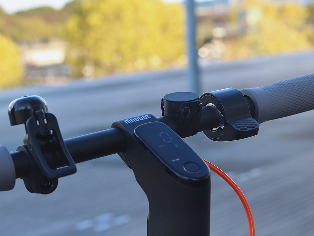 Installation du support Shapeheart sur une trottinette - vue en situation. Image montrant le support installé sur un guidon de trottinette, idéal pour suivre une navigation GPS ou écouter de la musique.